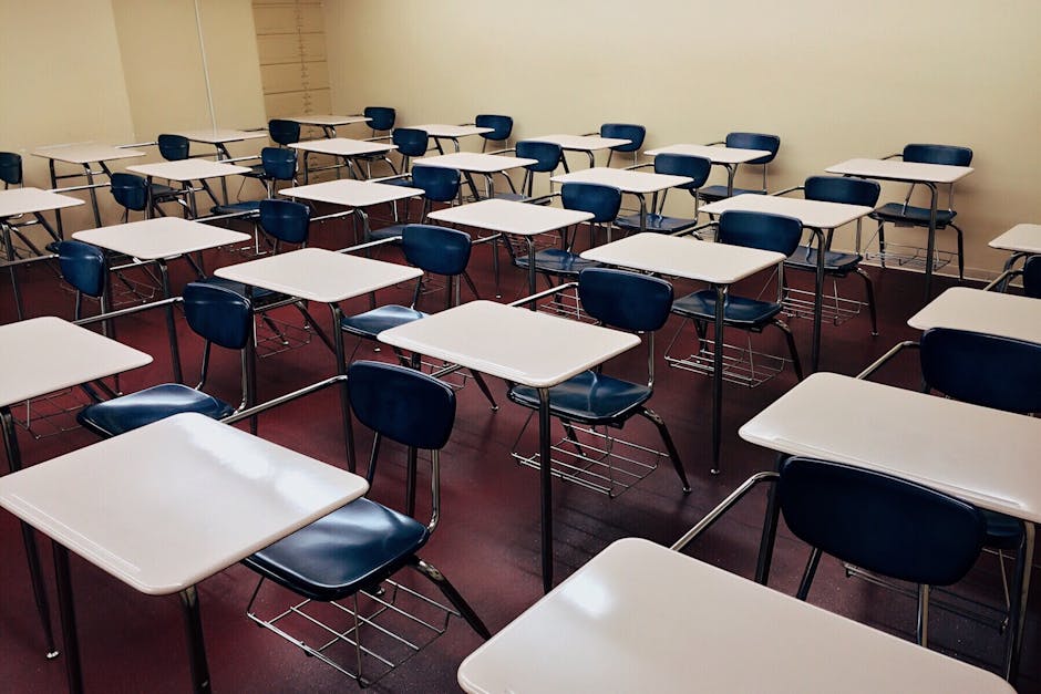 An indoor view of a modern, clean classroom with rows of empty desks and chairs